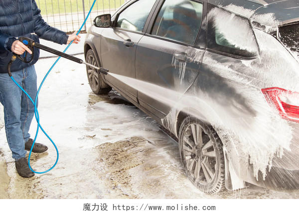 男人洗车使用高压水和泡沫的清洗车